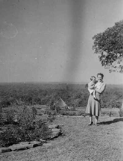 Betty carrying Kate, in front of the DC's house in Mwinilunga.